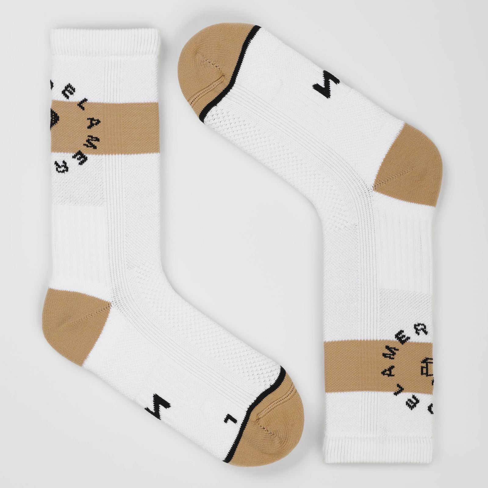 A pair of white padel socks with beige toe and heel sections, a beige horizontal stripe on the cuffs, and black text reading 'PADEL AMERICANO' arranged in a circle. One sock is upright and the other is angled diagonally, set against a clean, light gray background.
