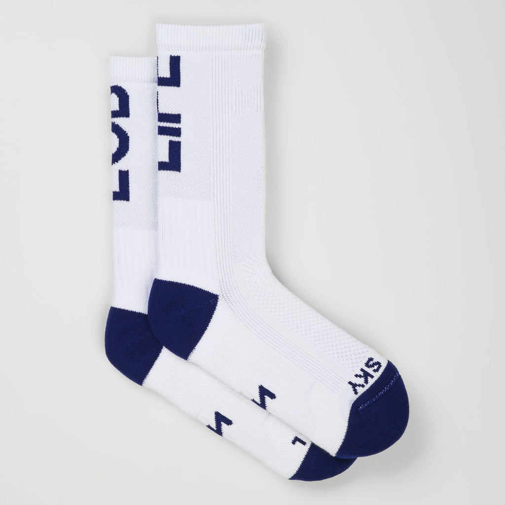 Two white padel socks with navy blue accents on the heels, toes, and cuffs, featuring the statement 'MASTER THE SKY' on the toes and 'LOB LIFE' on the cuffs, displayed against a light gray background.